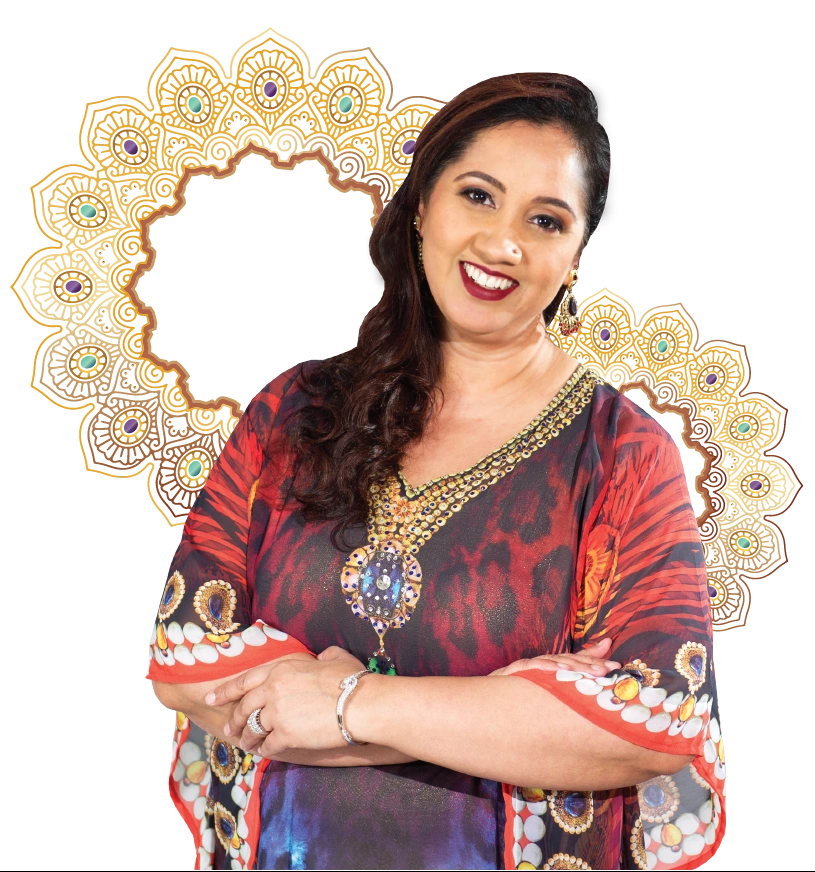 A woman in a colorful dress standing in front of an ornate frame, showcasing her expertise as a high achievement coach and astrologer.